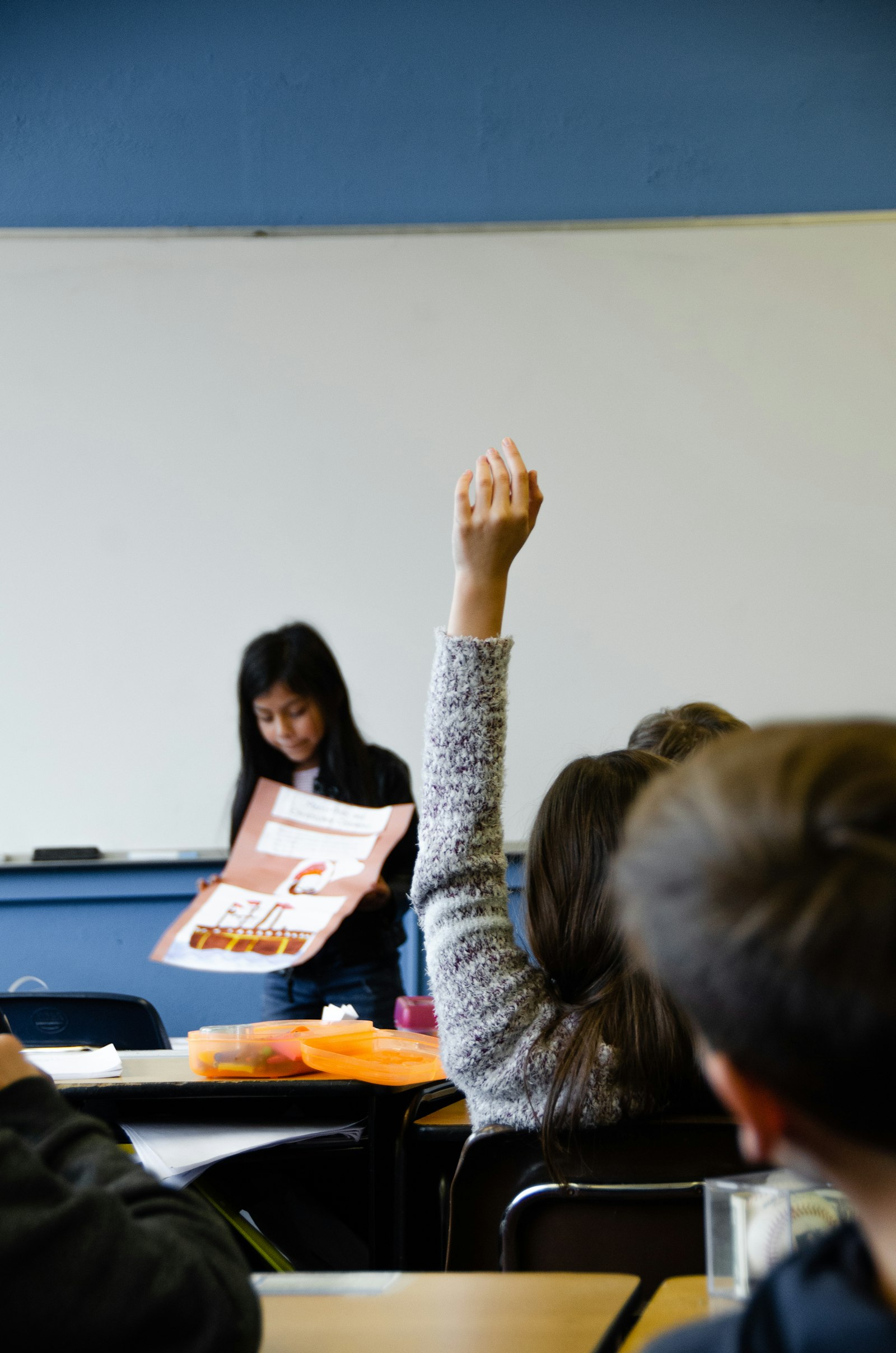 Student raising hand to answer in classroom